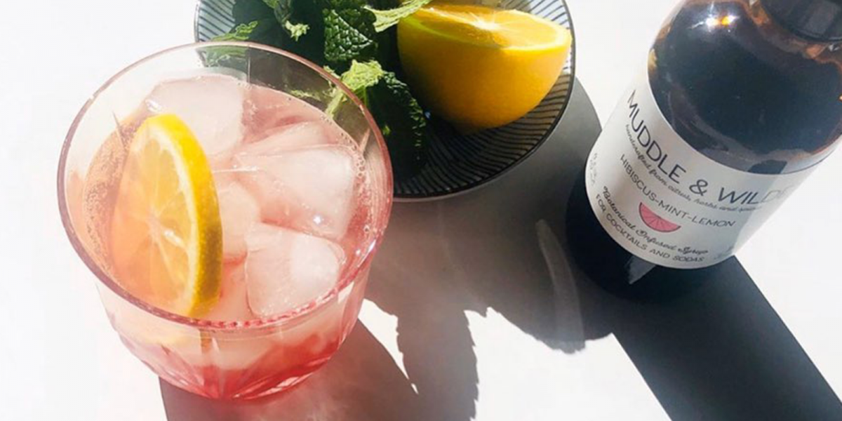 Summer cocktails with lemon and mint and a bottle of flavor